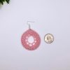 Reference image of a light pink crocheted dream catcher earring next to a quarter.