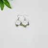 White crochet rose earrings laying flat on a white backdrop