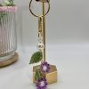 Crochet purple flower bag charm hanging on a gold hook