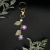 Crochet purple flower bag charm on a black backdrop