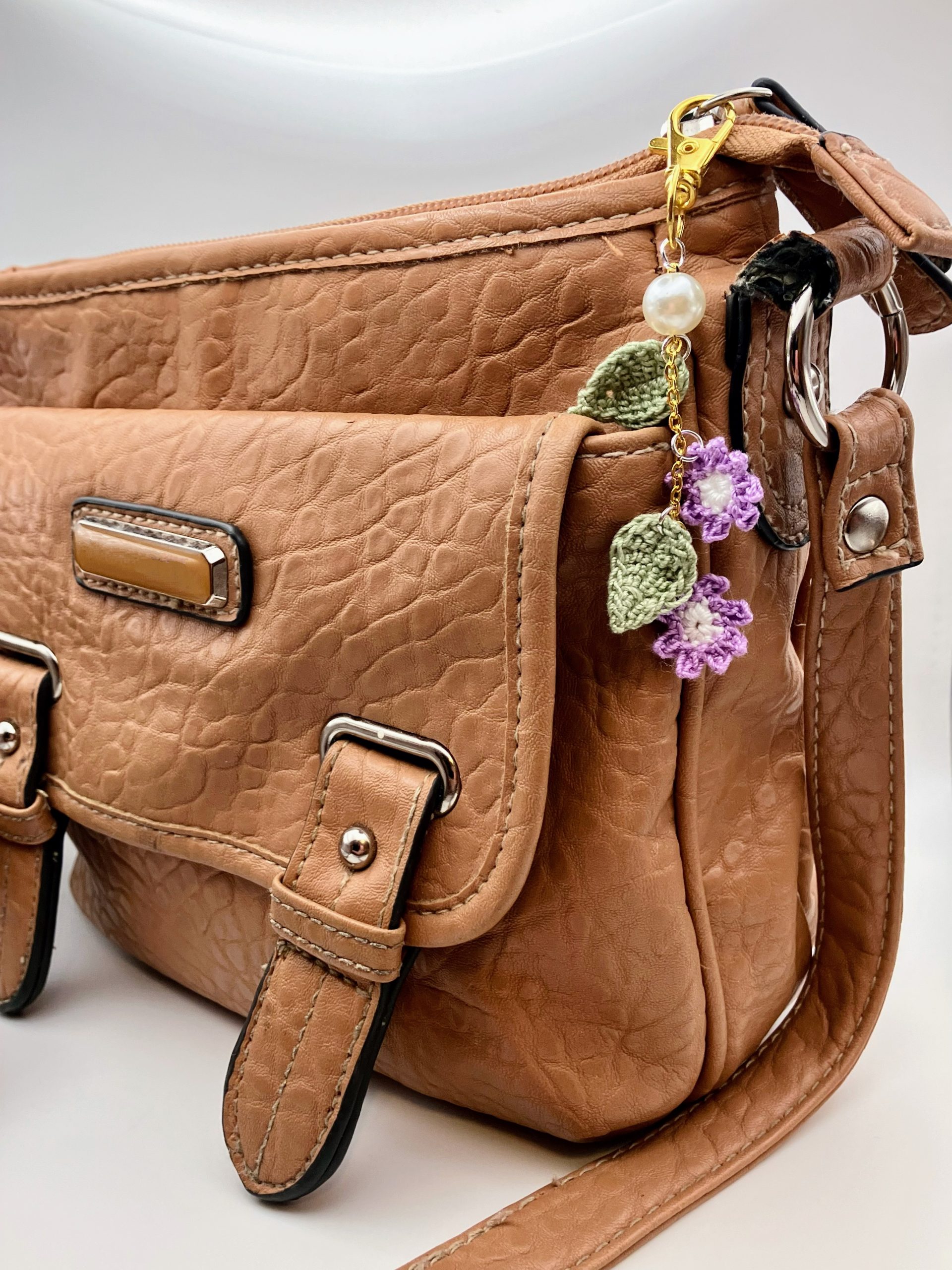 Purple flower bag charm on a brown purse