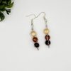 Wood beaded dangle earrings laying next to each other on a white backdrop