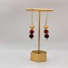Wood beaded dangle earrings hanging on a gold earring stand
