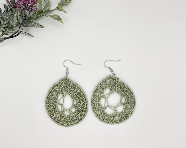 Crochet green dream catcher earrings laying next to each other on a white backdrop