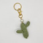 Crocheted green cactus with pearl accent on a gold key ring