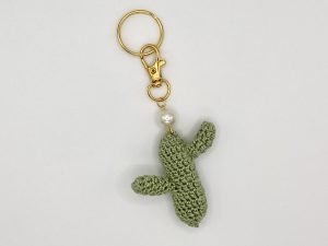 Crocheted green cactus with pearl accent on a gold key ring