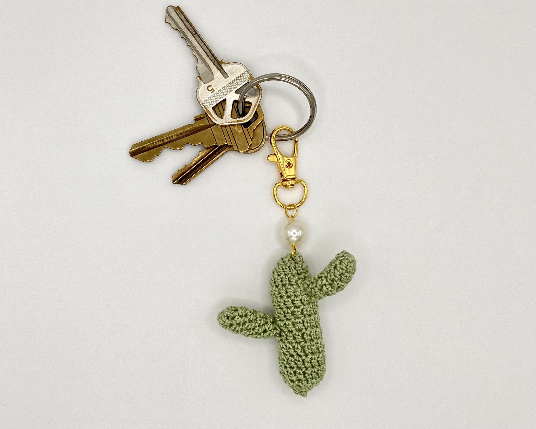 Crocheted green cactus with pearl accent, on a gold snap clip, on a key ring