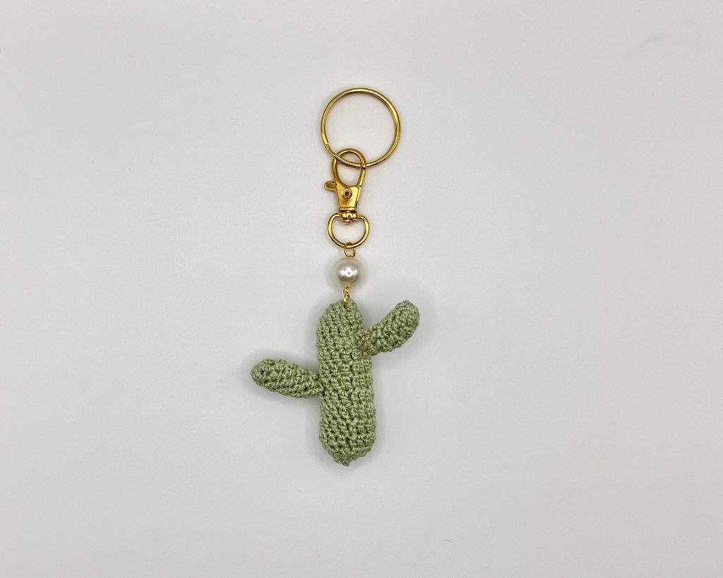 Crocheted green cactus on a gold key ring with pearl accent