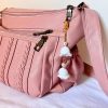 Lily bag charm with pearls on a gold chain displayed on a pink purse