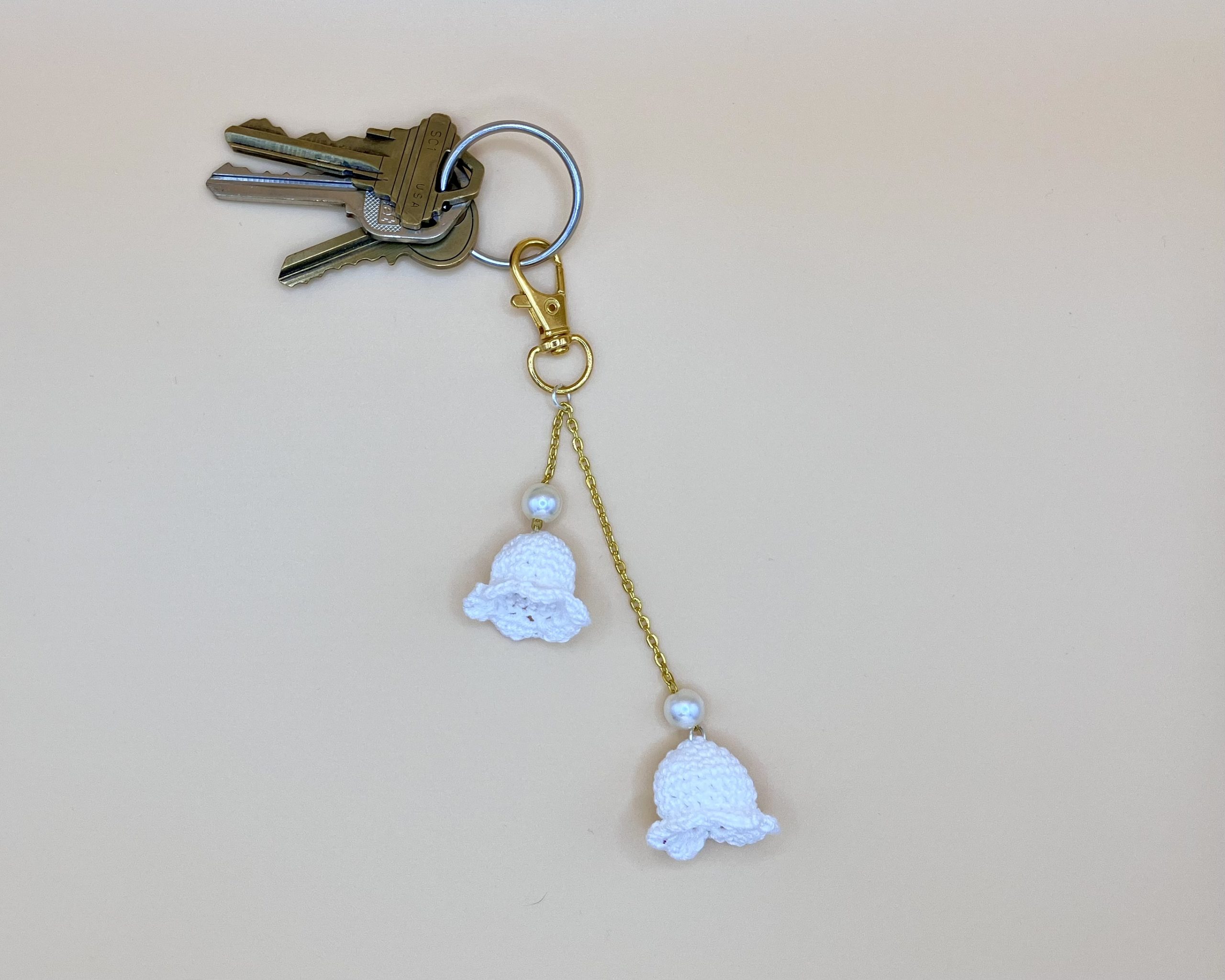 Lily bag charm with pearls, on a gold chain with keys