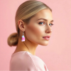 Blonde haired Woman wearing wearing pastel, against a pink backdrop, showcasing handmade crochet pink candy corn earrings