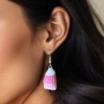 Close up of woman wearing crochet candy corn dangle earrings