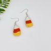 Crochet candy corn earrings laying flat on a white backdrop
