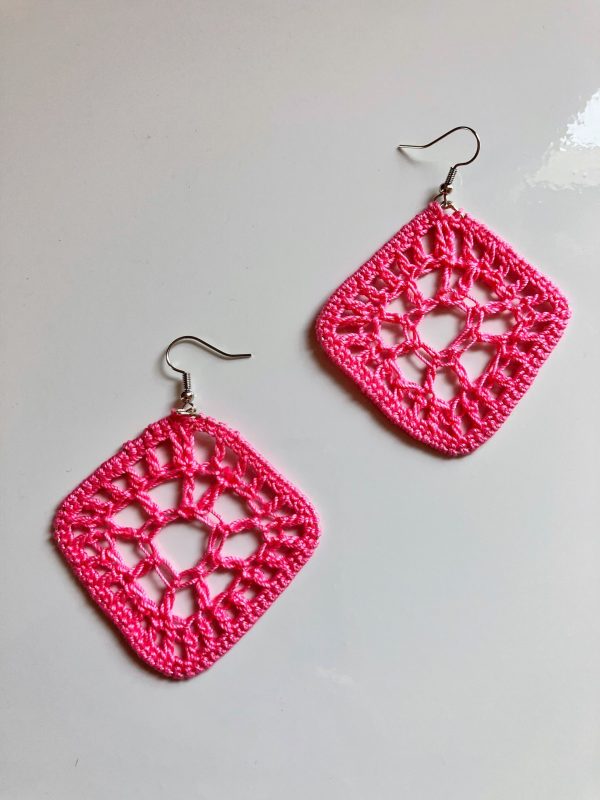 A pair of crochet pink diamond shaped earrings