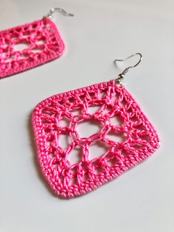 Close up of crocheted pink diamond shaped earring