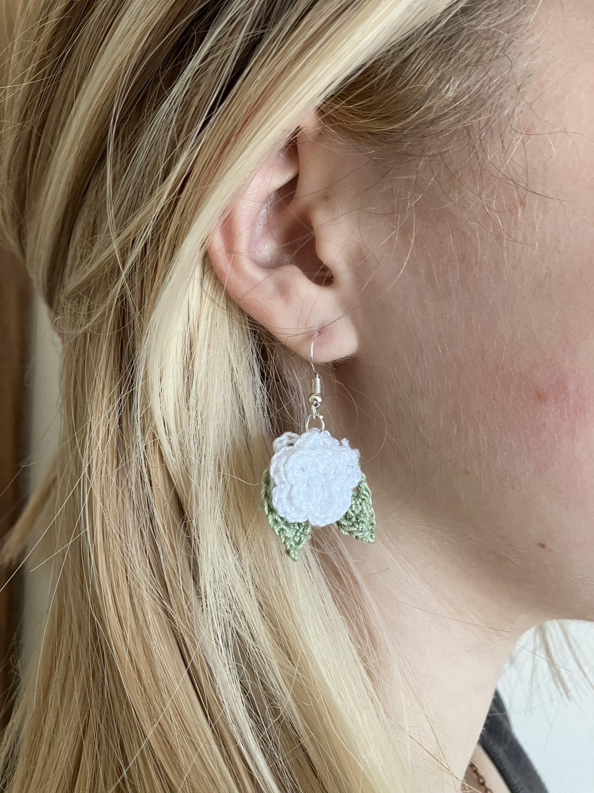 IMG_7881 A reference image of a model wearing white crochet rose earrings