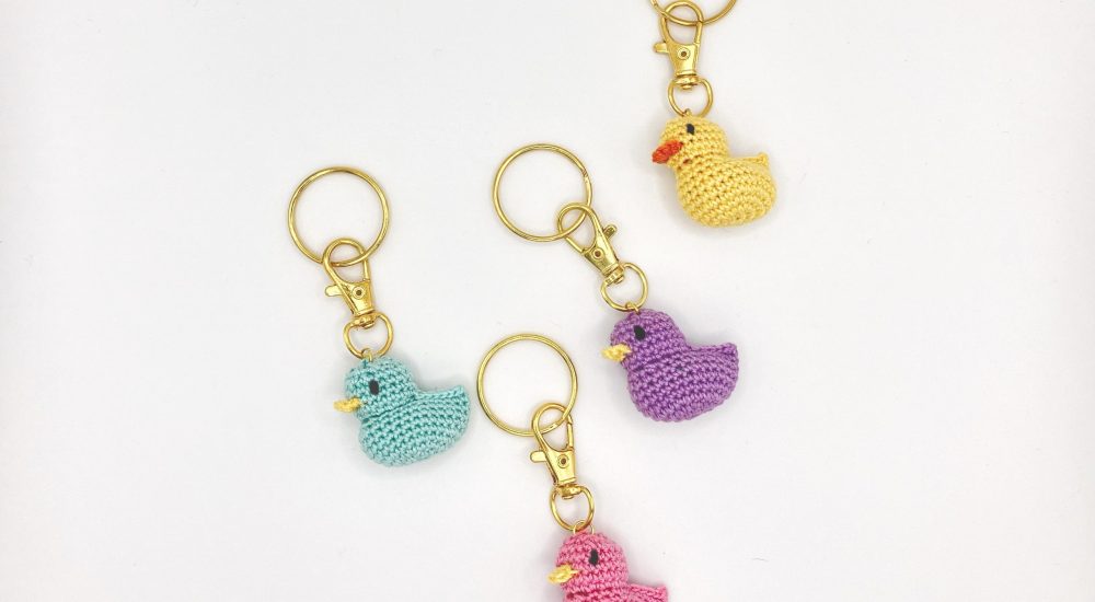 Small crochet duck keychain in vibrant colors, handmade with care.