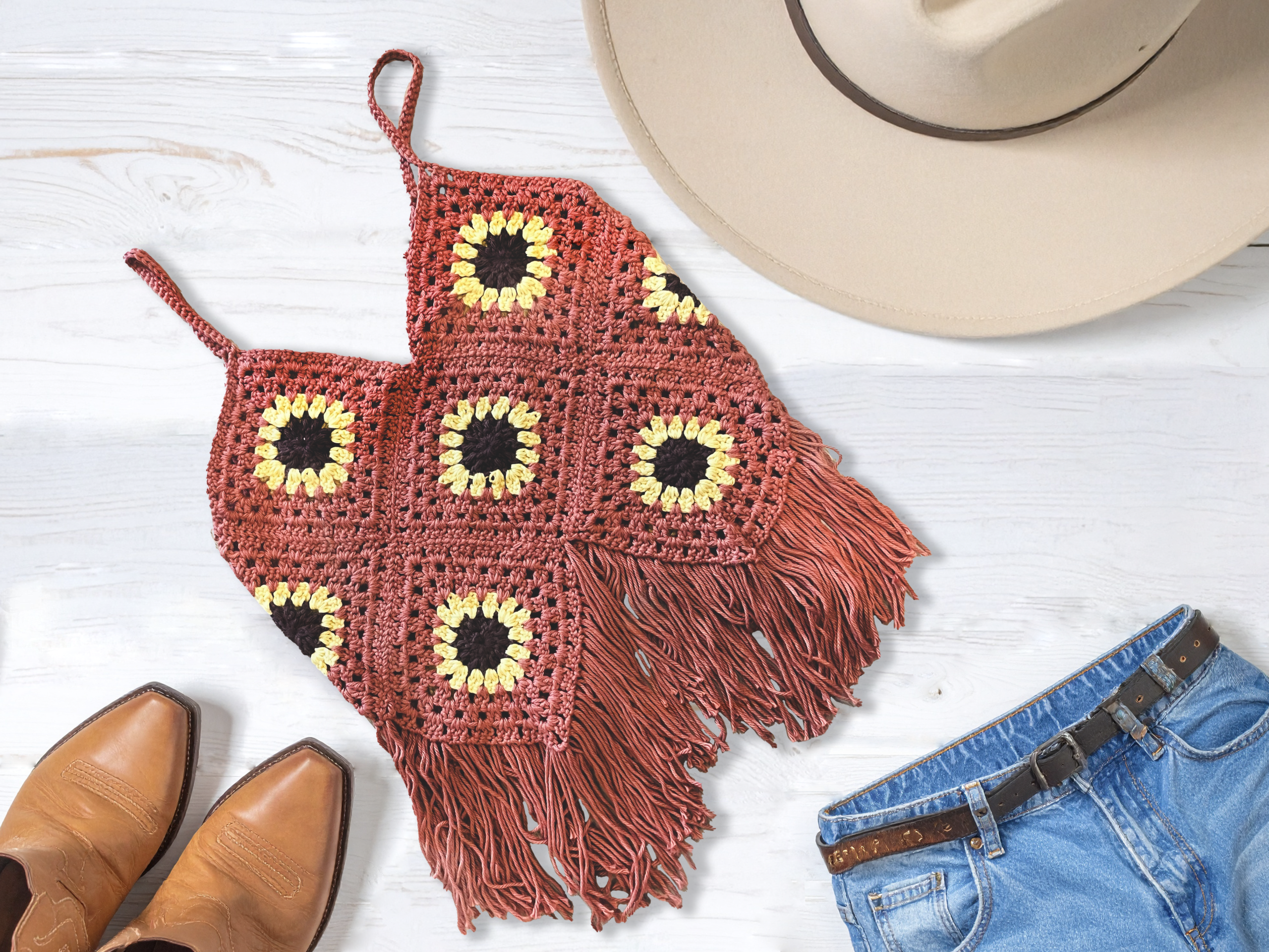 Flat lay of outfit with handmade Orange crochet sunflower top