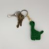 Green dinosaur keychain on a keyring of keys
