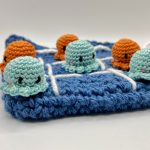 Close up of crochet octopus tic tac toe playing pieces